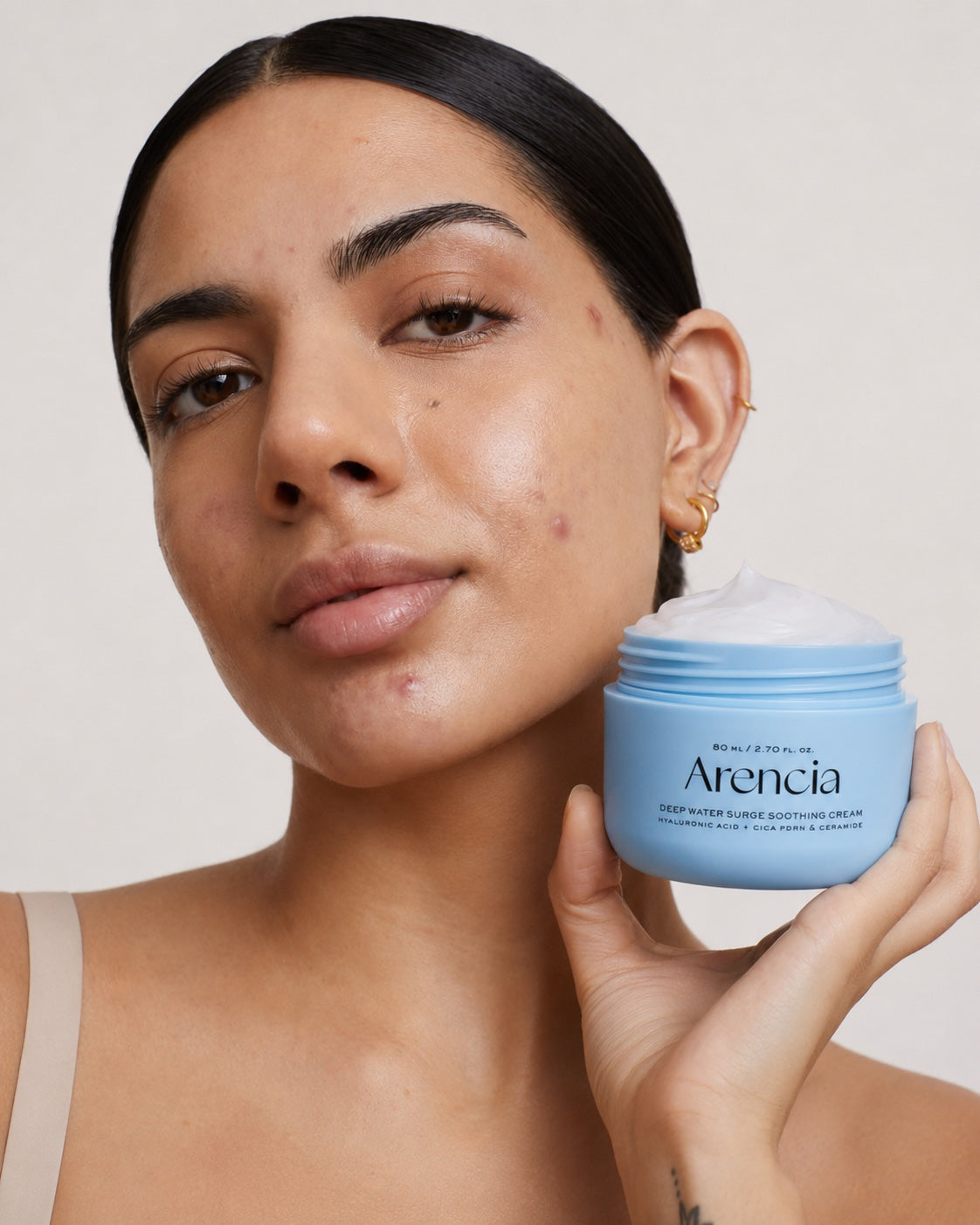 Breaking out skin women holding the arencia cream