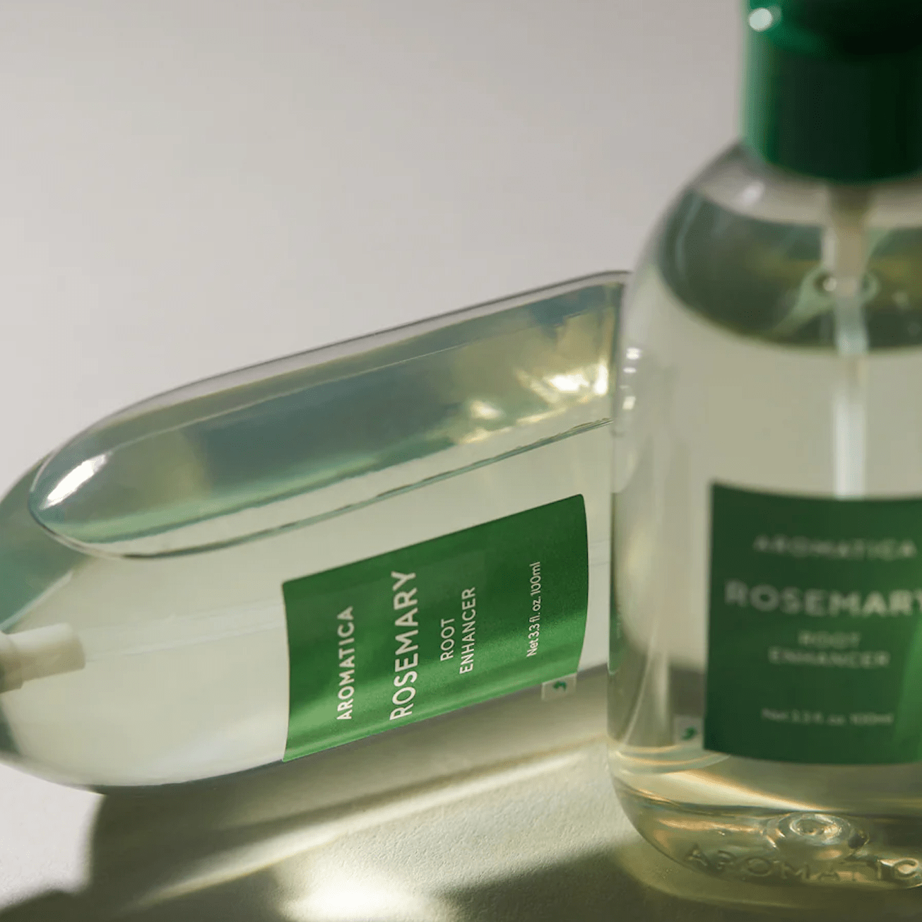 Aromatica rosemary root enhancer bottles on grey background