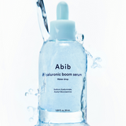 Hyaluronic boom serum bottle with water droplets on a white background
