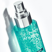 Teal bottle with silver nozzle labeled 'Anua' on a white background