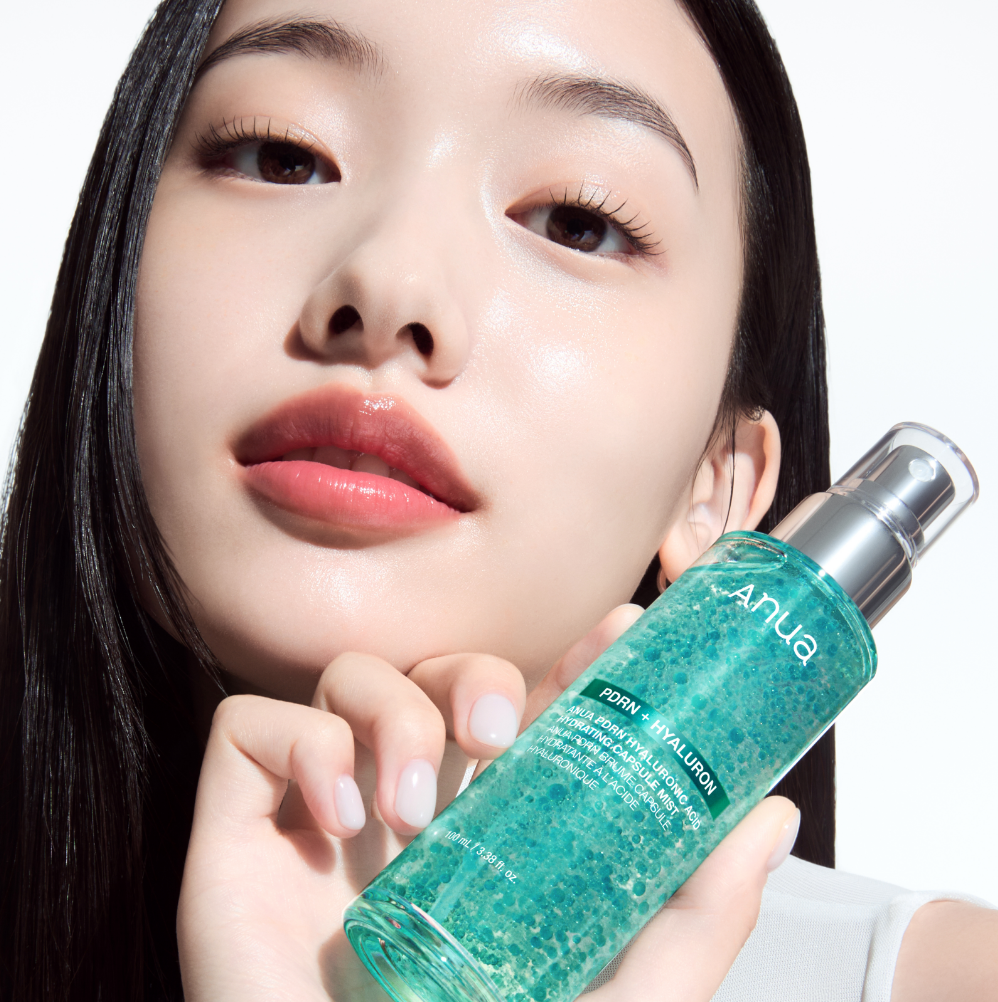 Woman holding a green skincare bottle with 'ANUA' branding.