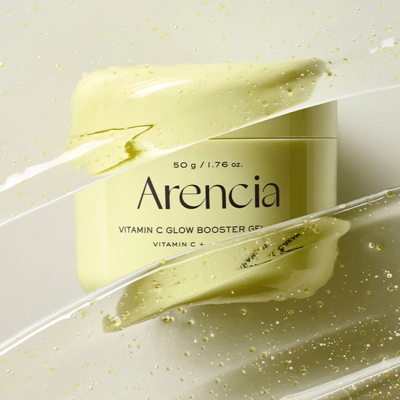 A jar of Arencia Vitamin C Glow Booster Gel shown with a smear of the pale yellow-green gel and clear liquid streaks on a light neutral background.