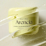 A jar of Arencia Vitamin C Glow Booster Gel shown with a smear of the pale yellow-green gel and clear liquid streaks on a light neutral background.