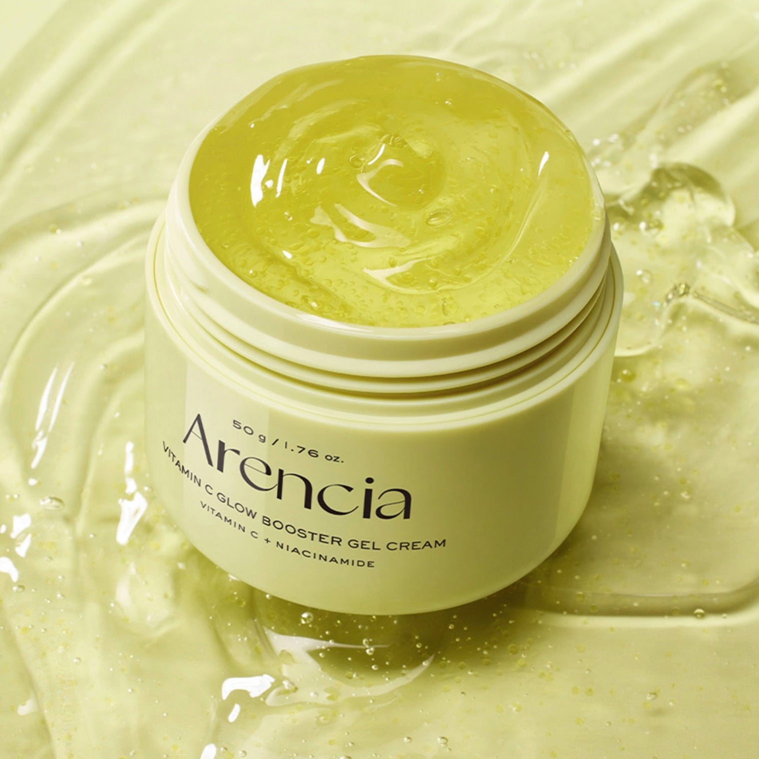 An open jar of Arencia Vitamin C Glow Booster Gel Cream, showing the pale yellow gel inside, set against a background of matching translucent gel.