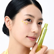 Women applying ARENCIA Vitamin C Booster Shot 30ml under her eye and holding the tube