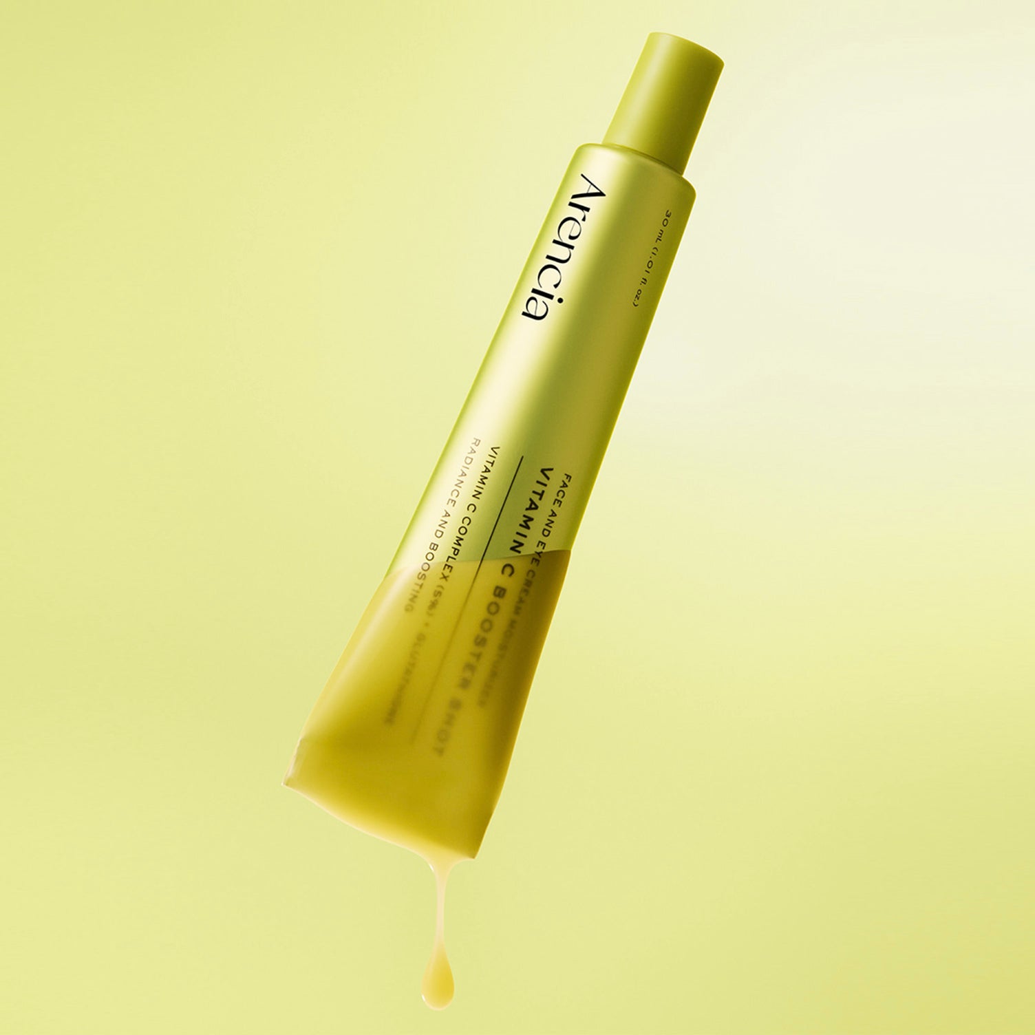ARENCIA Vitamin C Booster Shot 30ml tube dip on the yellow serum texture on light yellow gradient background