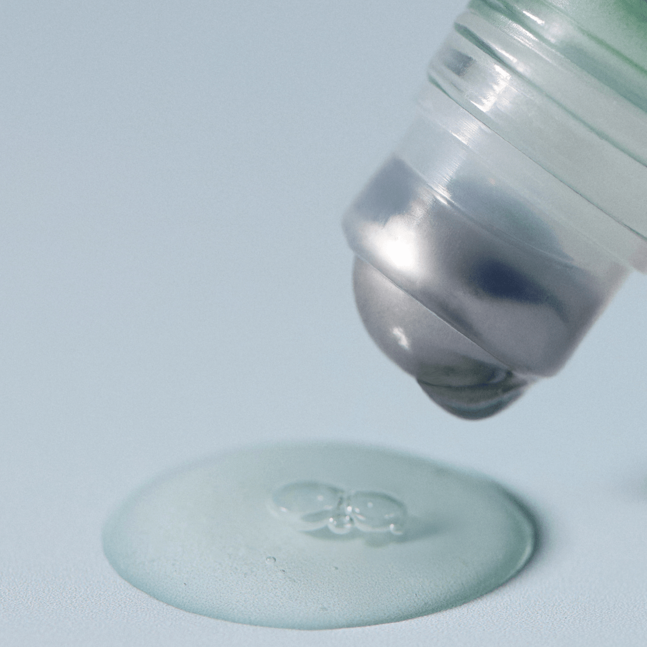 Close-up of a AROMATICA Rosemary Root Volumizing Scalp Ampoule cap being placed on a flat surface with a light gray background