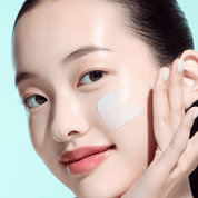 Woman applying ANUA PDRN Hyaluronic Acid Moisturizing Cleansing Foam with a light blue background