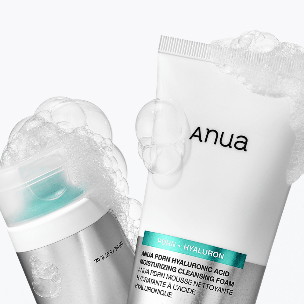 Anua skincare product with cleansing foam and sheet mask on a white background