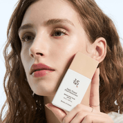 Woman holding a bottle of BEAUTY OF JOSEON Daily Tinted Fluid Sunscreen SPF 50ml