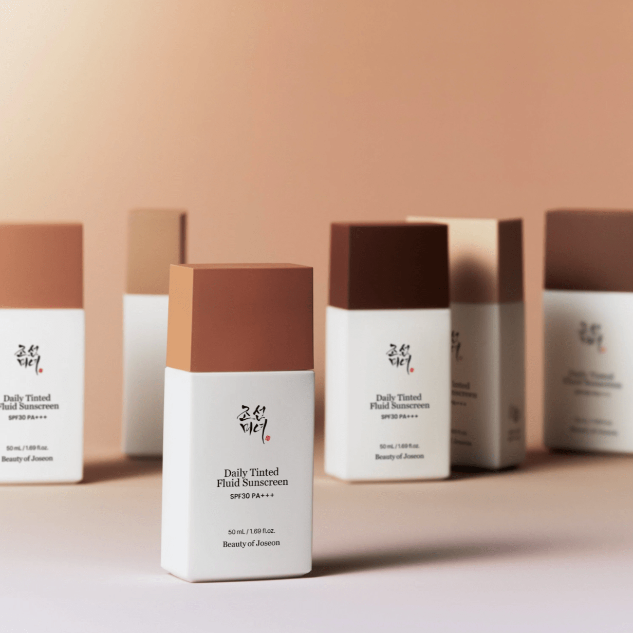 Row of skincare products with a focus on 'Daily Tinted Fluid Sunscreen' on a neutral background