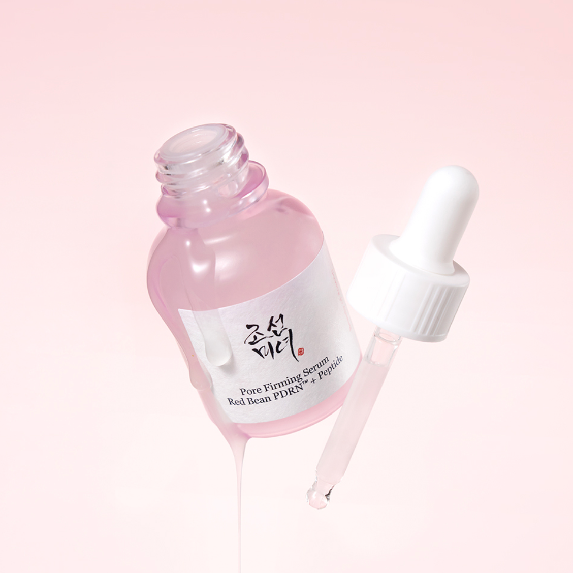 BEAUTY OF JOSEON Pore Firming Serum Red Bean PDRN+Peptide serum dropper bottle with a white label and white dropper, shown on a soft pink background with serum dripping from the bottle.