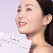 Woman holding a Biodance Rejuvenating Caviar PDRN Real Deep Mask with a blurred background