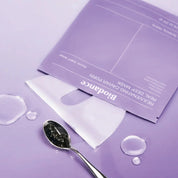 Biodance Rejuvenating Caviar PDRN Real Deep Mask with spoonful of dark powder on a purple background
