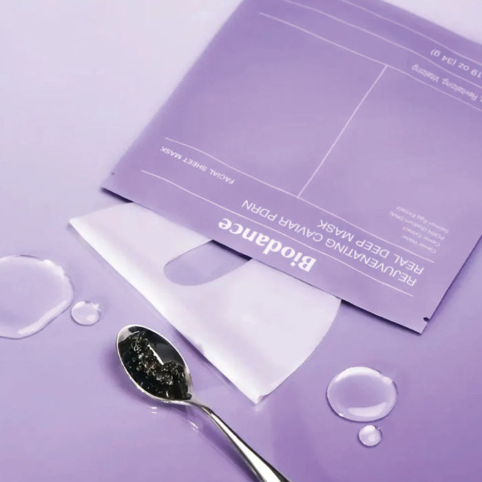 Biodance Rejuvenating Caviar PDRN Real Deep Mask with spoonful of dark powder on a purple background