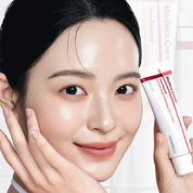 Women holding Centellian24 Madeca cream time reverse tube on hand next to her face