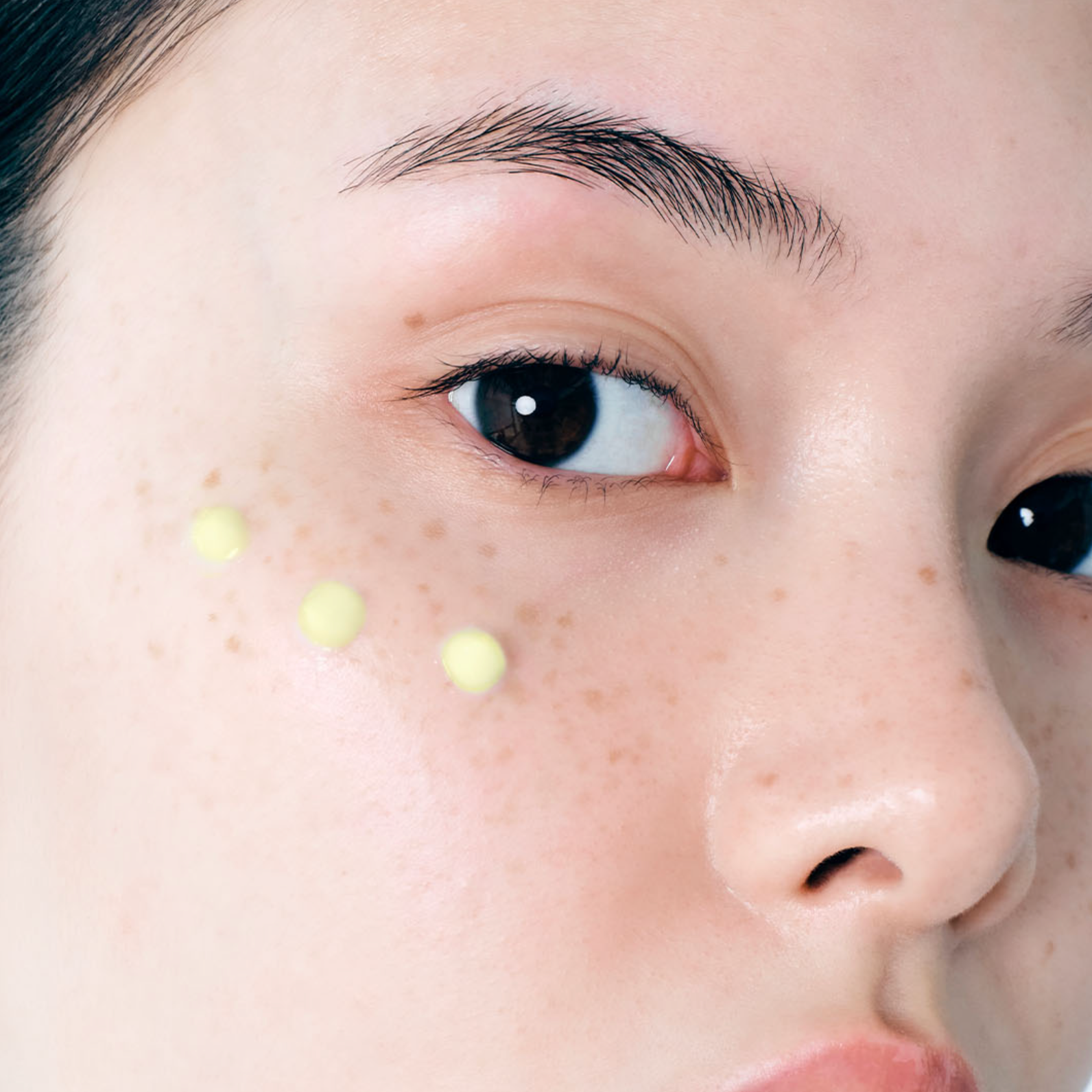 Close-up of a person's face with DR. ALTHEA Pure Retinol 0.15% Cream on the cheek, showing a natural skin texture and pore detail.