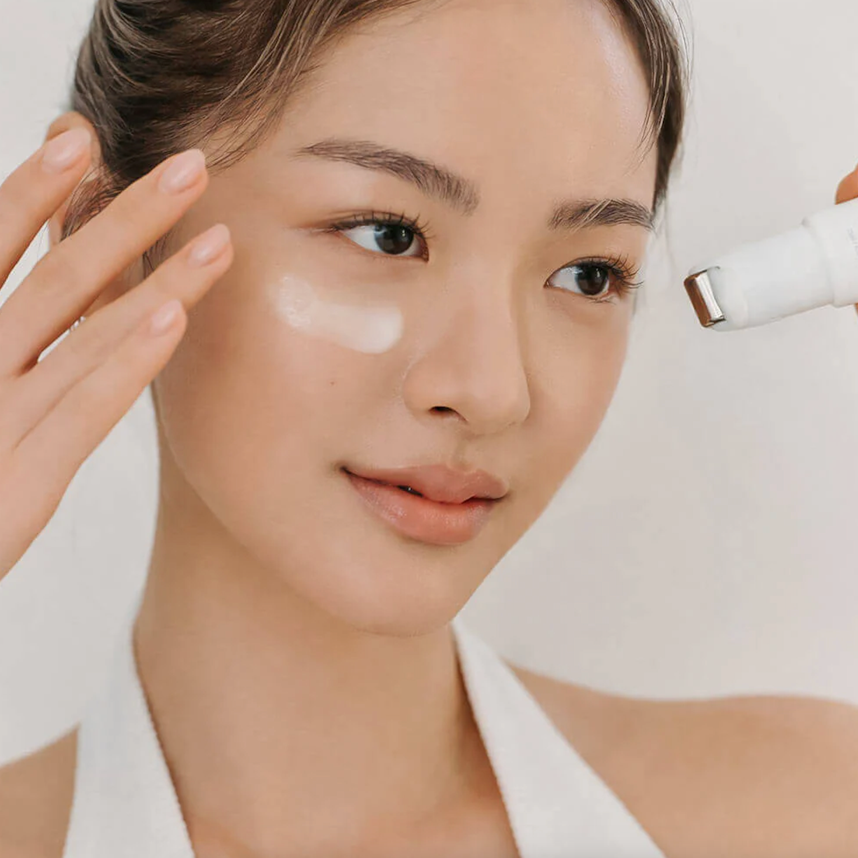 Women applying DR. ALTHEA Retinol Flat Iron Eye Roller under eye area