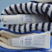 DR. ALTHEA Retinol Flat Iron Eye Roller tubes lay between the towels