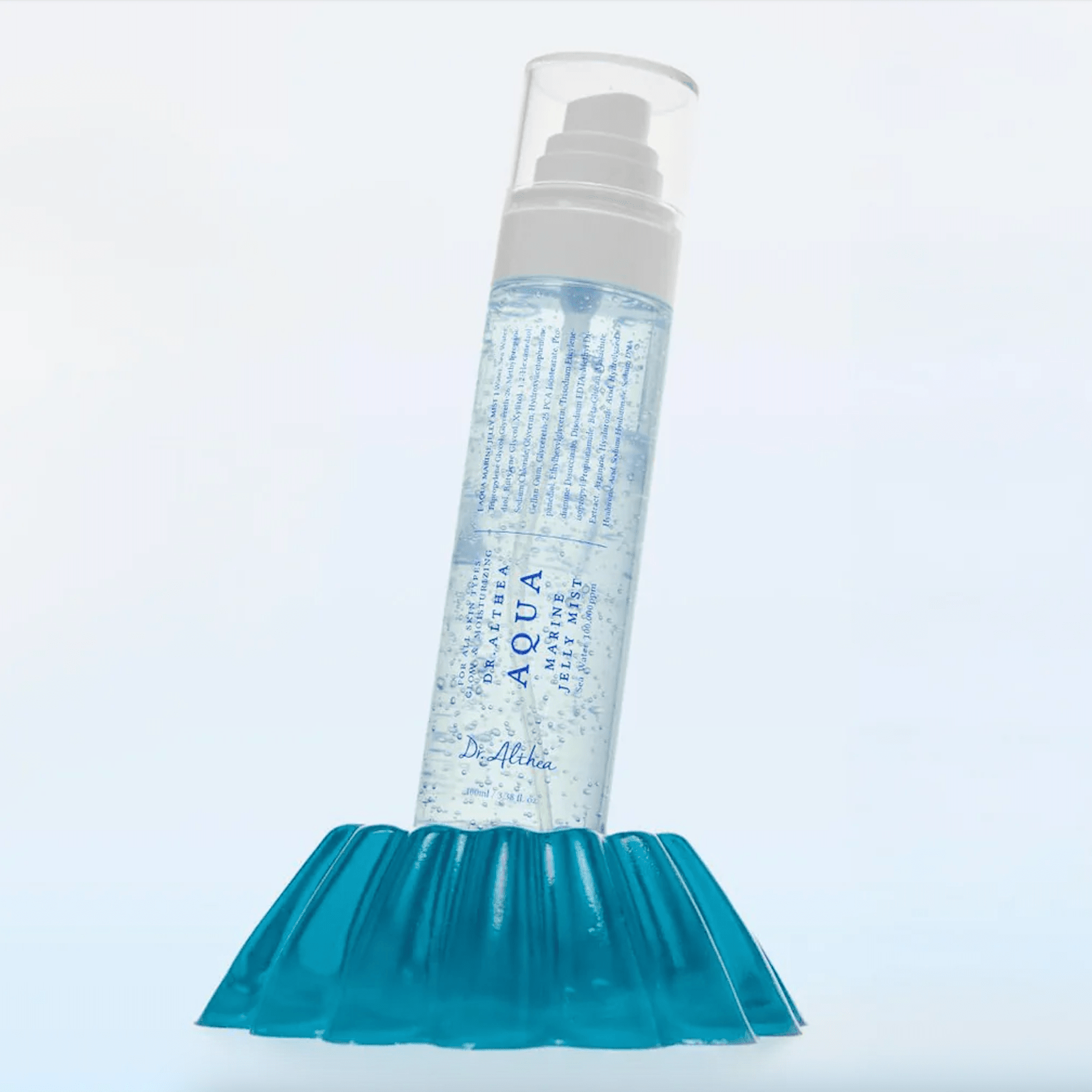 Dr. Althea Aqua Marine Jelly Mist bottle labeled 'Aqua' on a blue textured stand with a light gray background