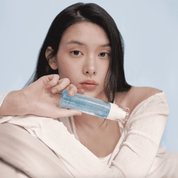 Woman holding a Dr. Althea Aqua Marine Jelly Mist with a plain background