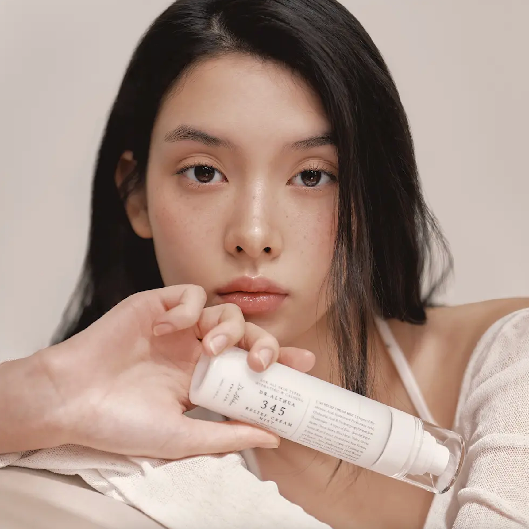 Women holding the Dr.Althea 345 Relief Cream Mist bottle in front of her face