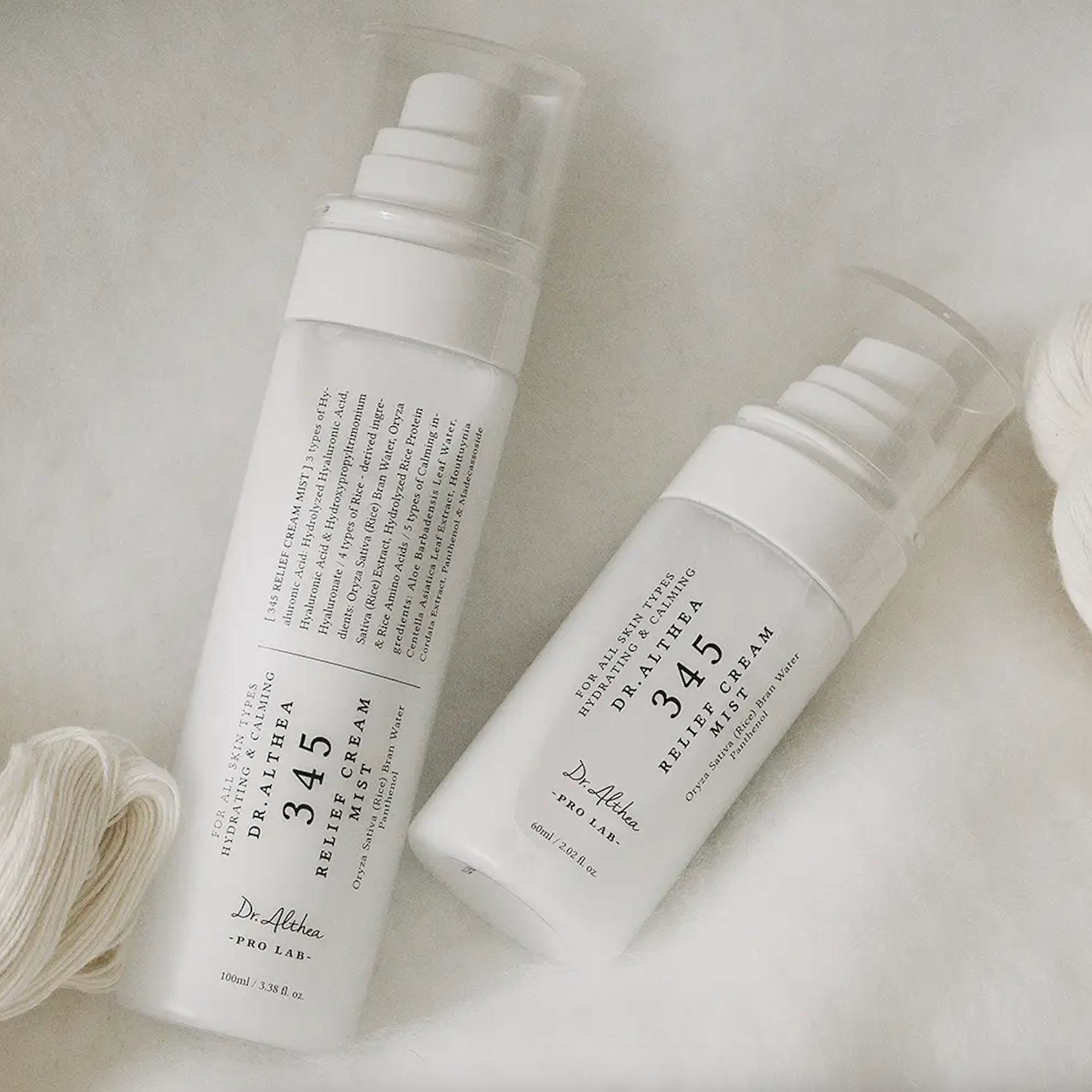 Dr.Althea 345 Relief Cream Mist bottles lay on white cotton fabric 