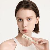 Woman holding a Dr. Reju-All Advanced PDRN Rejuvenating Lip Serum (10ml) against a plain background