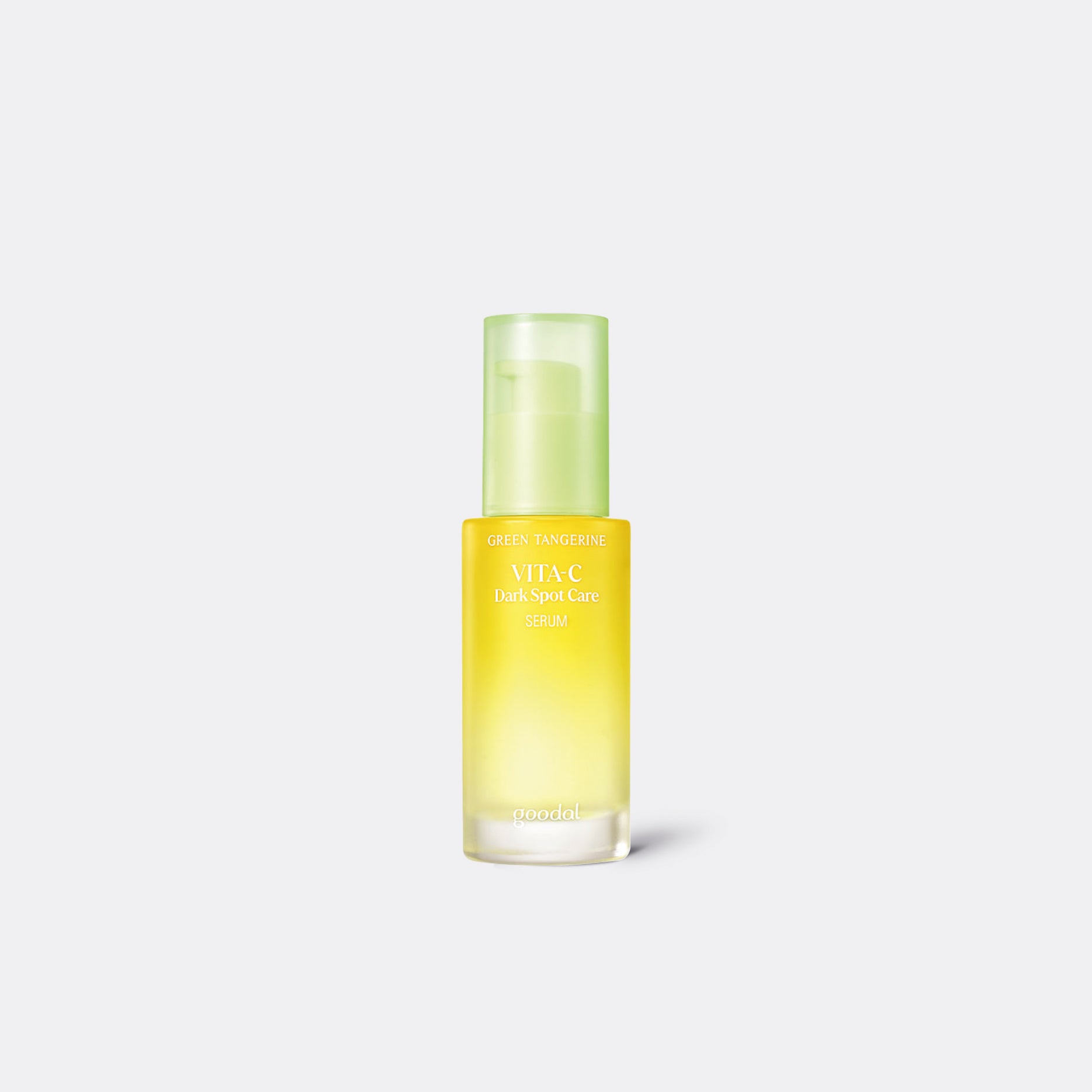 A bottle of Goodal Green Tangerine Vita C Dark Spot Care Serum with a yellowish liquid visible through the clear glass.