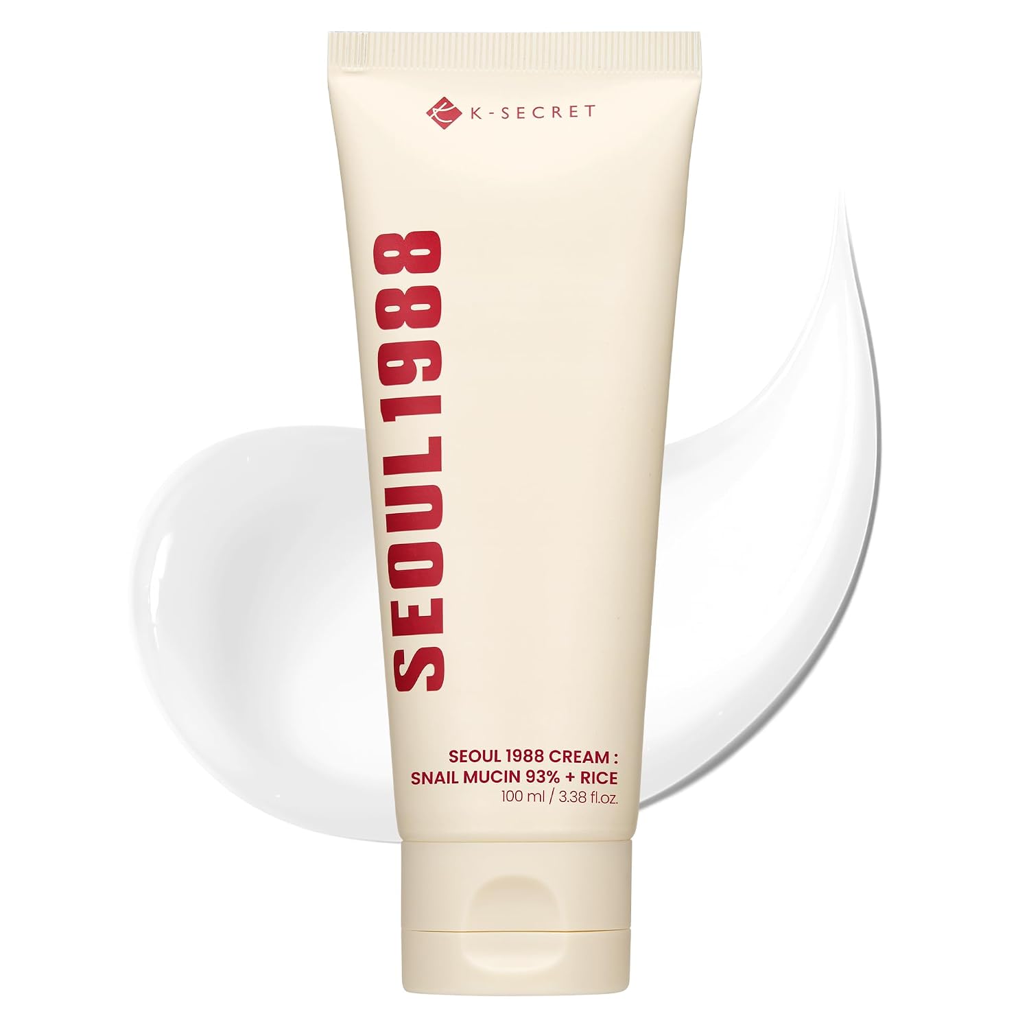 A cream-colored squeeze tube of K-SECRET Seoul 1988 Cream: Snail Mucin 93% + Rice with red text, set against a white background with a decorative white smear behind it.