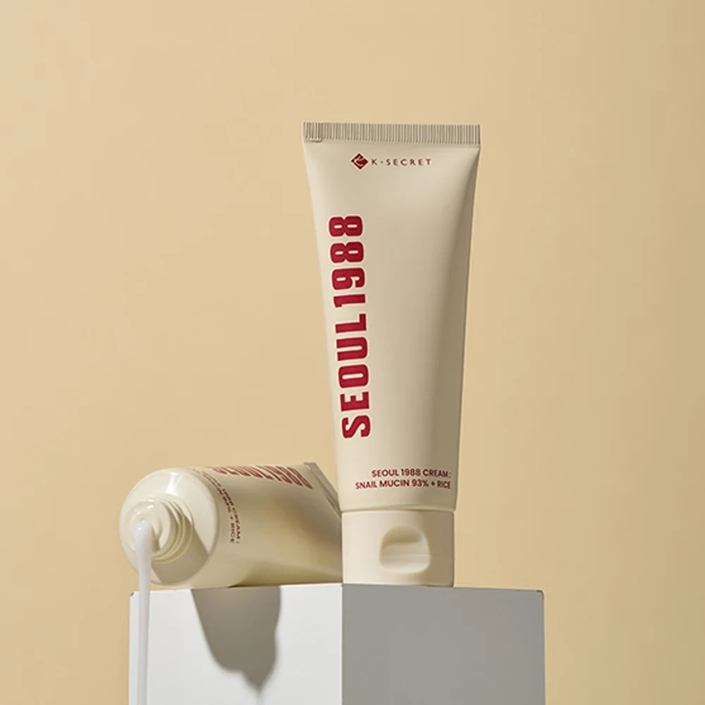Tube of K-SECRET Seoul 1988 Cream: Snail Mucin 93% + Rice on a beige background