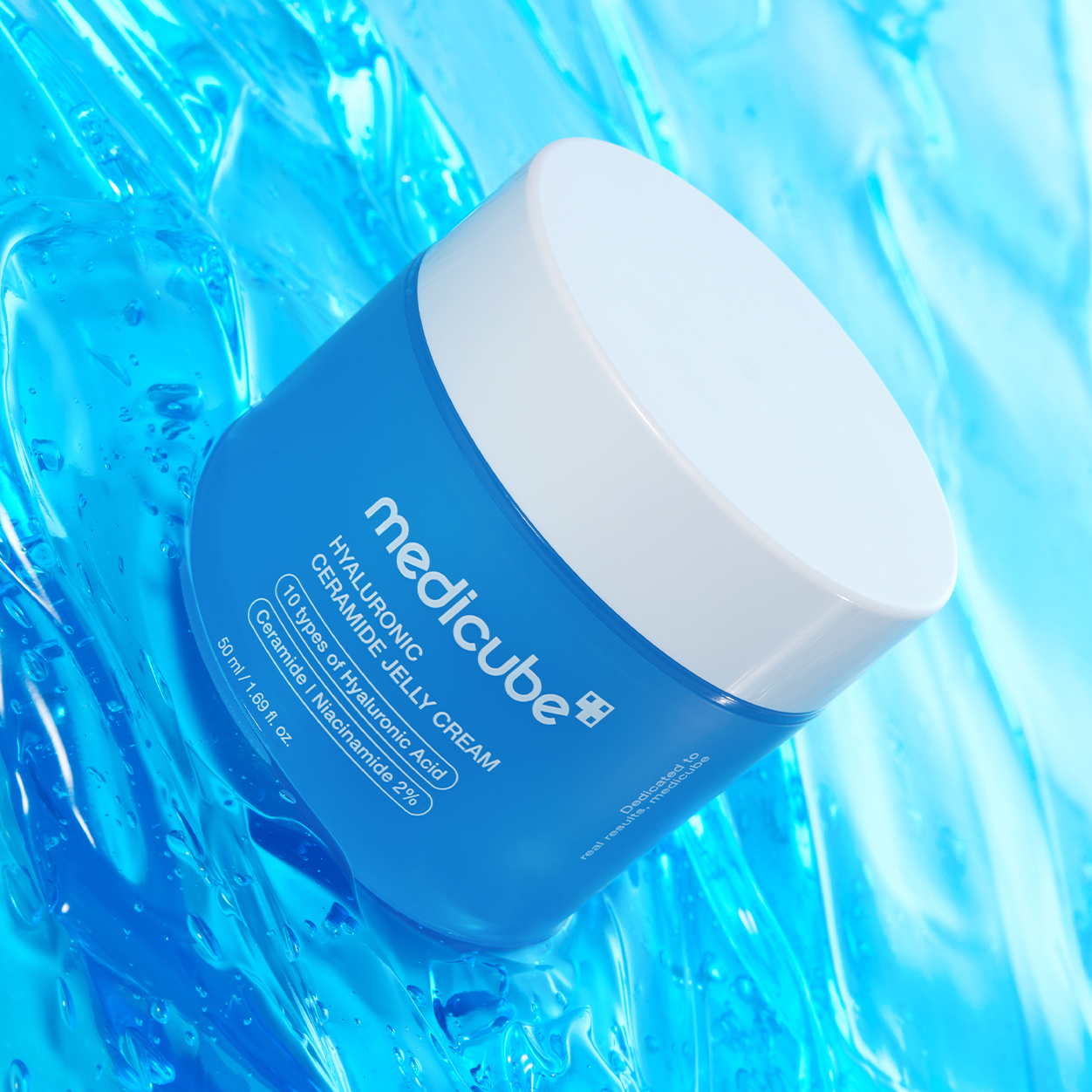 A blue and white jar of MEDICUBE Hyaluronic Ceramide Jelly Cream , set against a glossy, textured blue background.