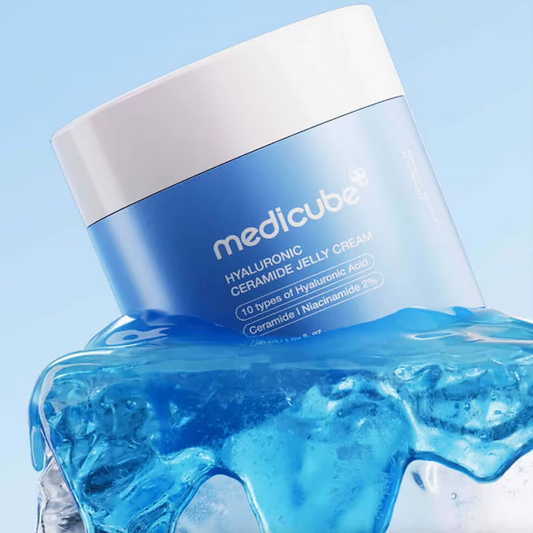 A blue and white jar of MEDICUBE Hyaluronic Ceramide Jelly Cream, styled with a splash of translucent blue gel at its base against a light blue background.