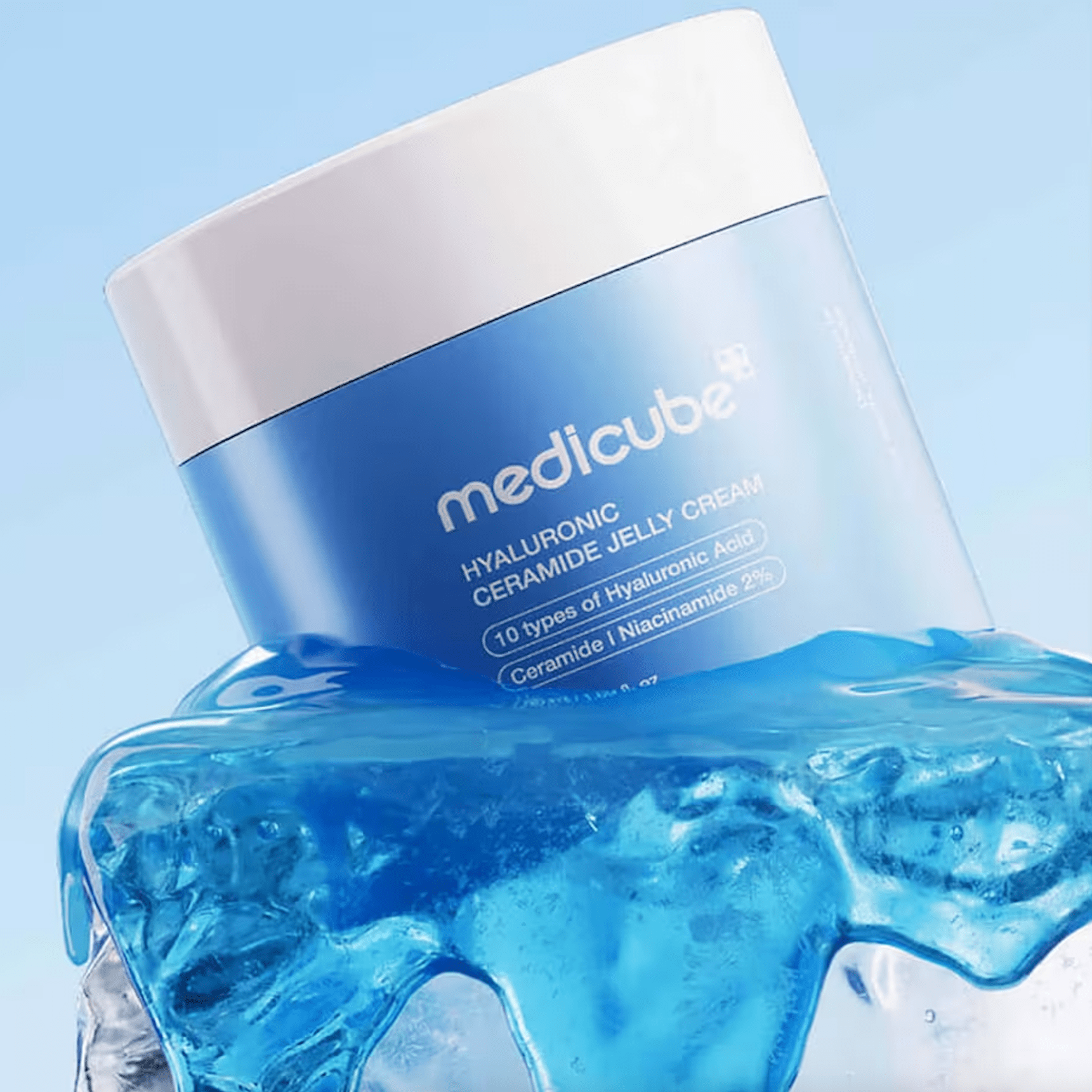 A blue and white jar of MEDICUBE Hyaluronic Ceramide Jelly Cream, styled with a splash of translucent blue gel at its base against a light blue background.