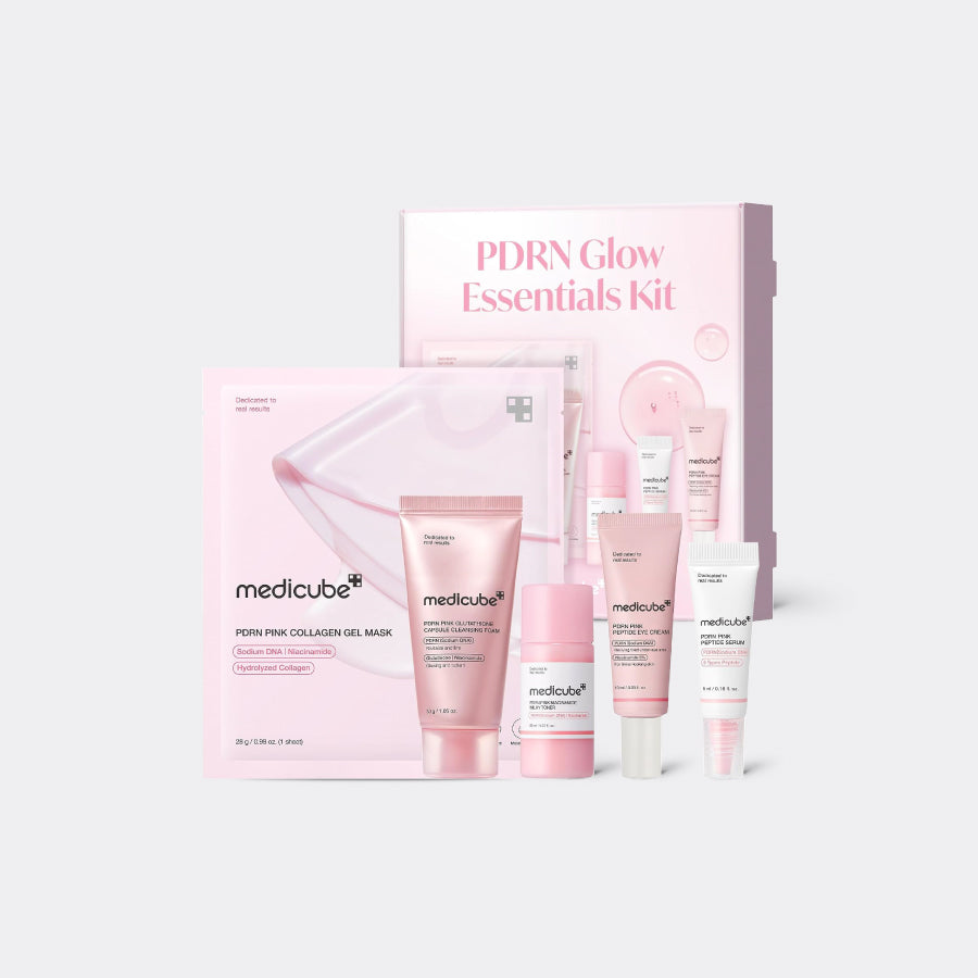 Medicube PDRN Glow Essentials Kit featuring a pink collagen mask pack, a pink serum tube, a pink cream bottle, a white tube, and a pink and white gift box on a light gray background.