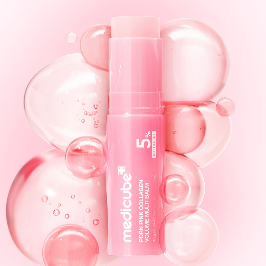 A pink cosmetic balm tube labeled medicube 5% Collagen Volume Multi-Balm, centered among translucent pink bubbles on a soft pink background.