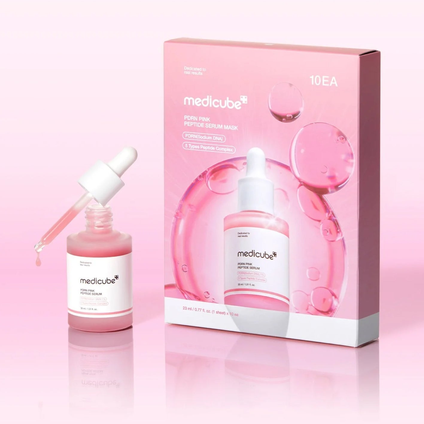 Medicube Fresh Pink Peptide Serum Mask set, featuring a pink serum bottle with a white dropper next to its pink packaging box on a light pink reflective background.