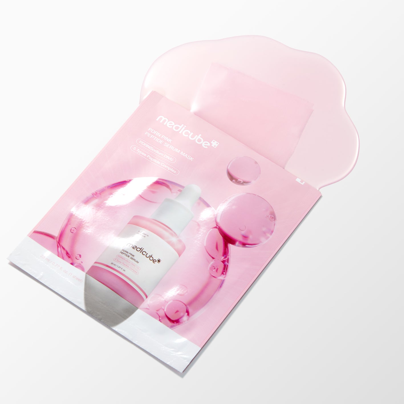 Medicube skincare set featuring a pink peel-off mask sheet and a matching pink pump bottle, presented in a clear, translucent pink pouch on a clean white background.