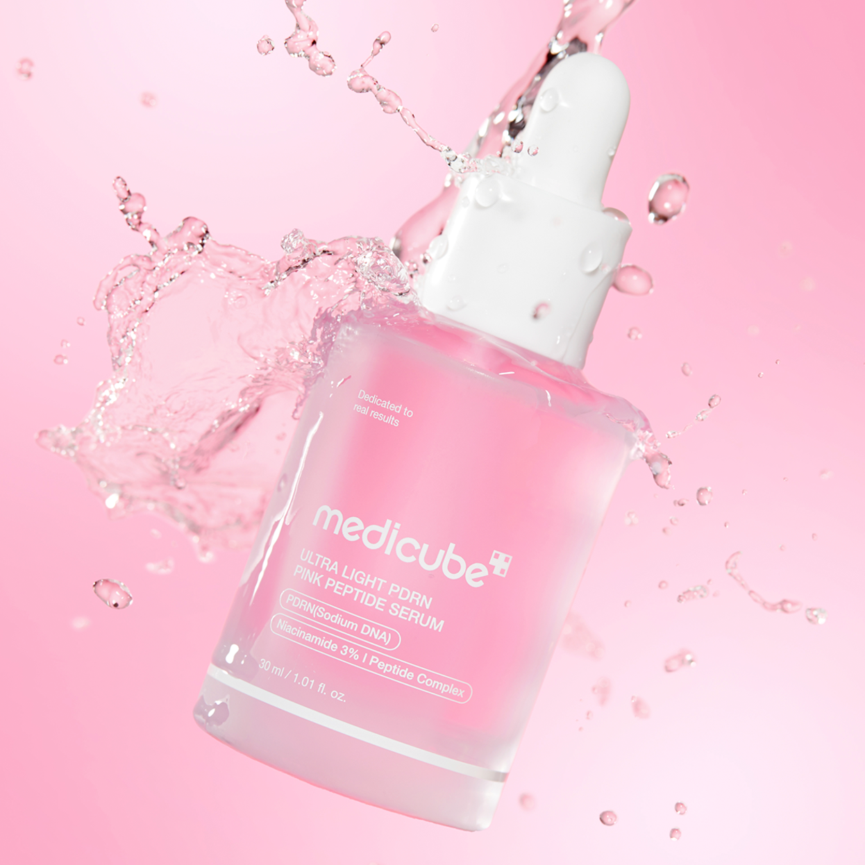 Medicube Ultra Light Firming Pink Peptide Serum in a frosted glass dropper bottle, surrounded by a dynamic water splash on a soft pink background.