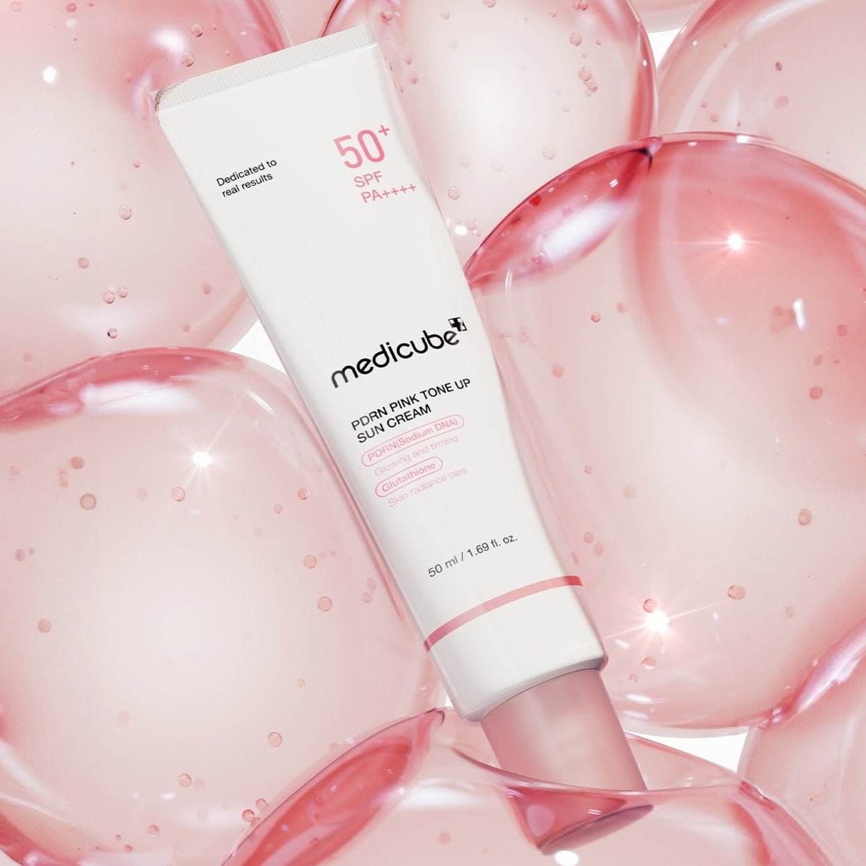 MEDICUBE PDRN Pink Tone Up Sun Cream 50ml with pink bubbles in the background