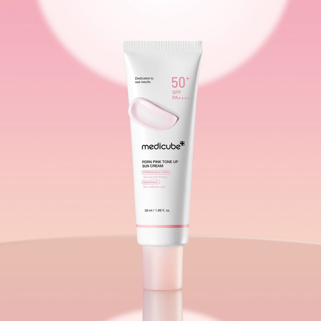 Tube of MEDICUBE PDRN Pink Tone Up Sun Cream 50ml on a pink background