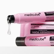 Pink tubes of Medicube hair care product with a droplet of serum on a white background