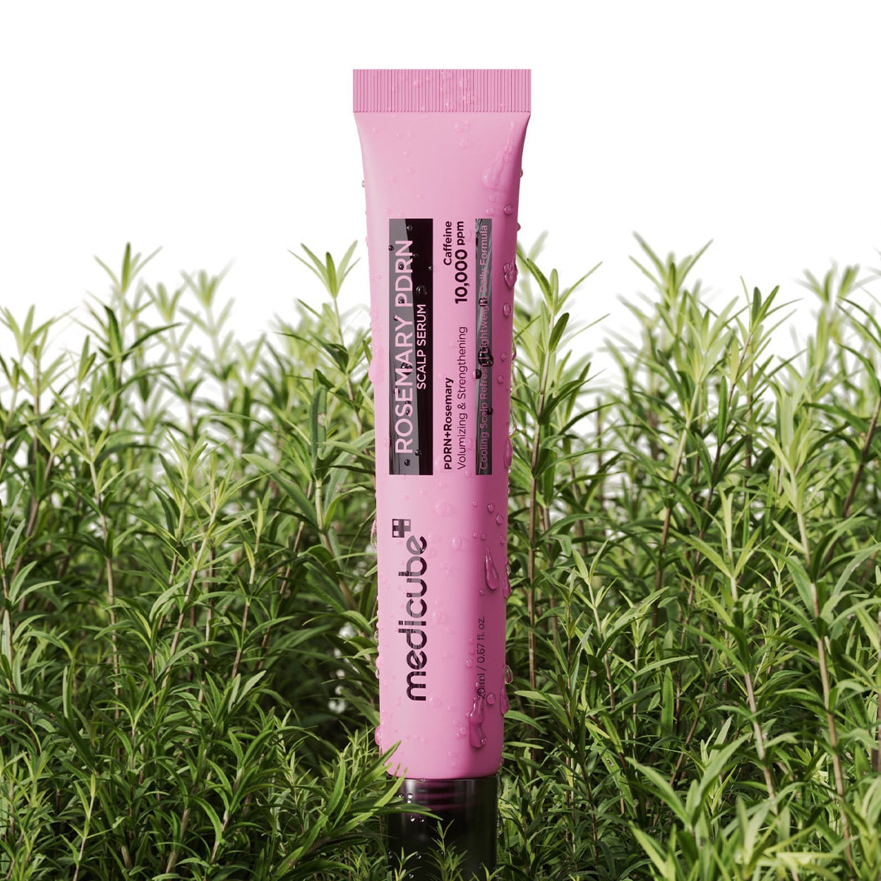 Pink tube of MEDICUBE Rosemary PDRN Scalp Serum in front of green plants