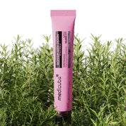 Pink tube of MEDICUBE Rosemary PDRN Scalp Serum in front of green plants