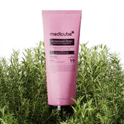 Pink tube of Medicube Rosemary Pdn conditioner surrounded by green plants