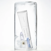 A white tube of SKIN1004 Madagascar Centella Azulene Peptide 5 Soothing Cream resting inside a clear cylindrical glass container filled with ice, on a white background.