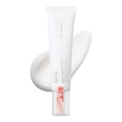A white squeeze tube of SKIN1004 Madagascar Centella PDRN 1.5 Cream with a clear cap showing pink liquid, set against a white background with a soft pink product smear behind it.