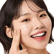 Woman applying VT COSMETICS Rice Ceramide Capsule Cream to her face with a white background