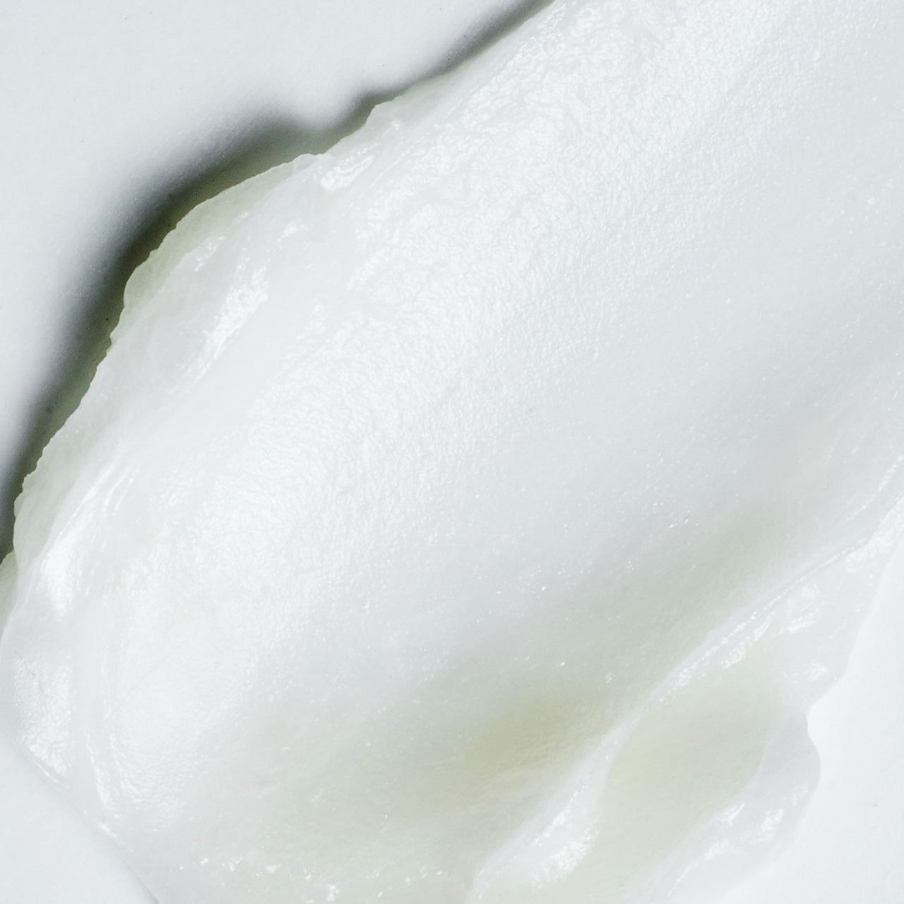 Close-up of smooth, white cream VT PDRN Essence Stick Balm on a light background