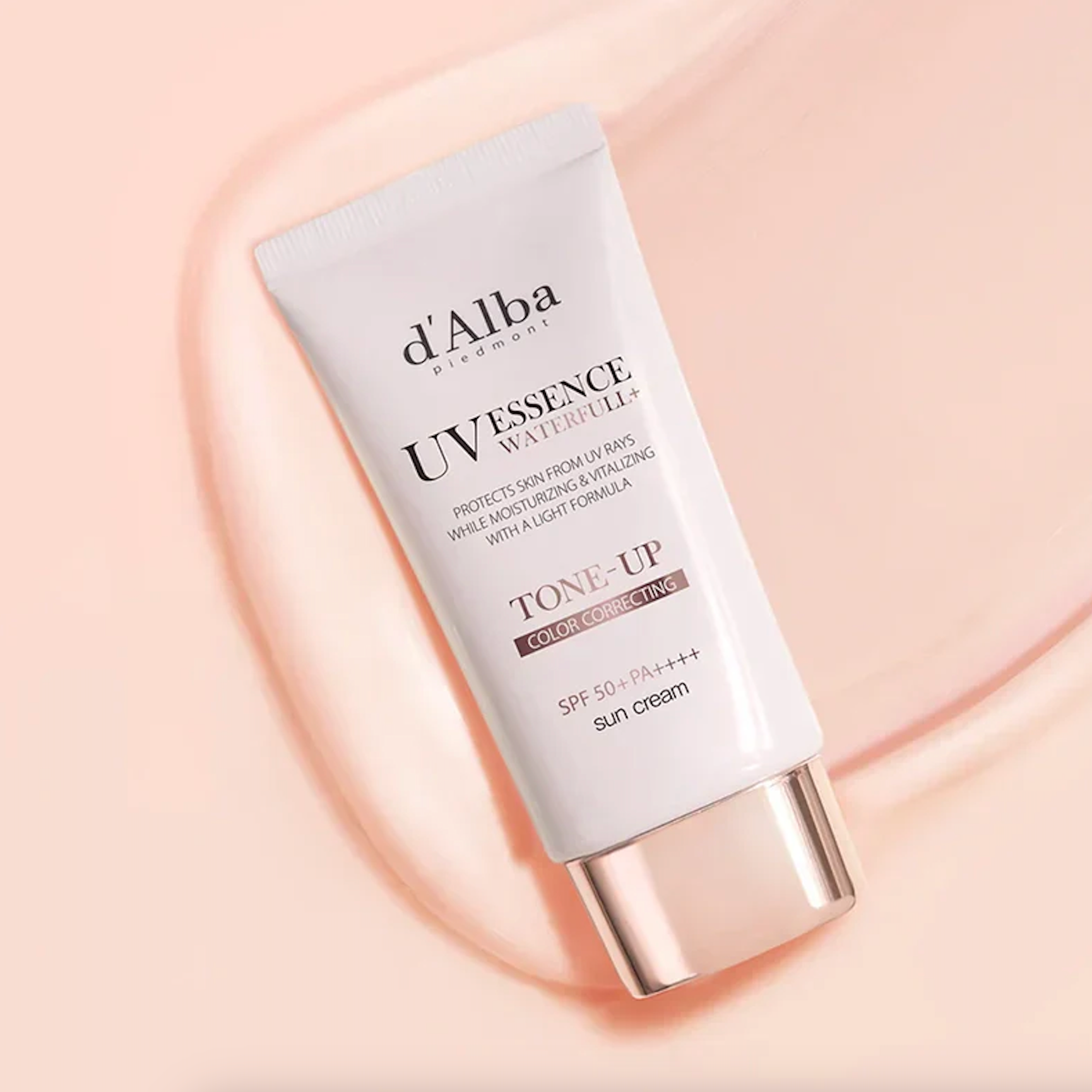 Tube of d'Alba Uvessence Waterfull Tone-Up Sun Cream on a pink background